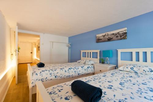 ポルトにあるOporto Blue Picaria - Unique Citycenter Apartmentの青い壁のベッドルーム1室(ベッド2台付)