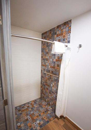 a bathroom with a shower with a roll up door at Sawari Hotel in San Carlos
