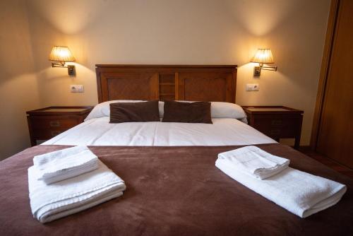 a bedroom with two beds with towels on them at Cabalo Furado Tui in Tui