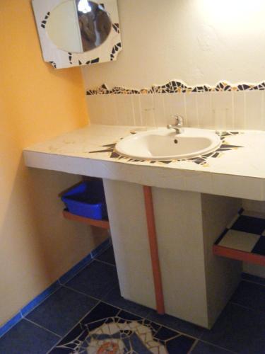 a bathroom with a sink and a mirror at Gîtes Mosaïques in Sainte-Rose