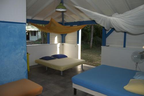 a bedroom with a bed and a bed and a couch at Gîtes Mosaïques in Sainte-Rose
