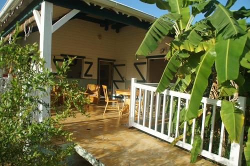 a porch of a house with a white railing at Gîtes Mosaïques in Sainte-Rose