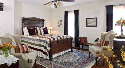 a bedroom with a bed and two chairs at Brickhouse Inn B&B in Gettysburg