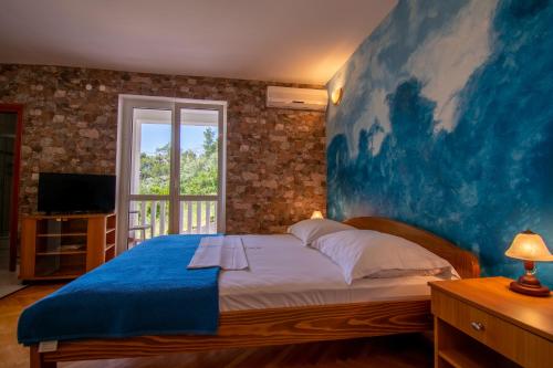 een slaapkamer met een groot blauw schilderij aan de muur bij Apartmani Petracie in Drvenik