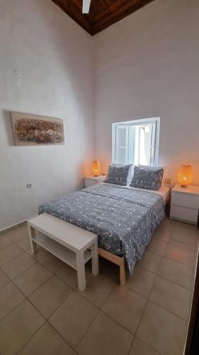 a bedroom with a large bed and a table at Kozas Art House, Symi in Symi