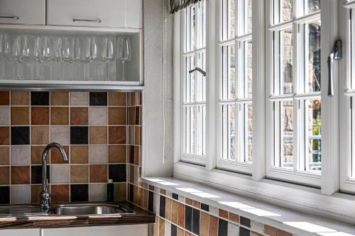 a kitchen with two windows and a sink at The Belle - A lovingly converted Grade II Listed home from home in Bakewell in Bakewell
