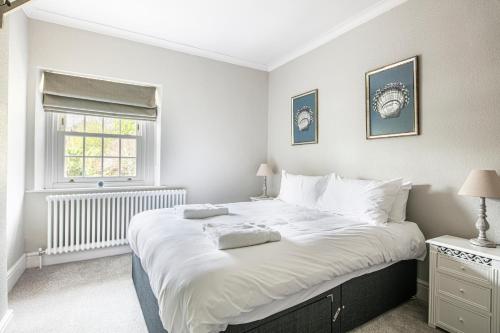 a large white bed in a bedroom with a window at The Belle - A lovingly converted Grade II Listed home from home in Bakewell in Bakewell