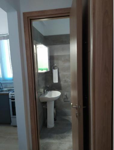 a bathroom with a sink and a toilet and a mirror at Πλατανακι 1 Family Friendly in Andros