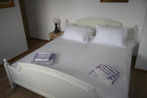 a white bed with two towels on top of it at Colev Rooms in Focşani