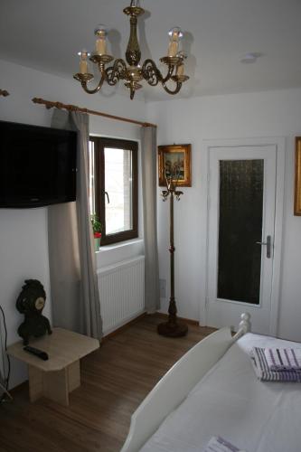 a bedroom with a bed and a chandelier at Colev Rooms in Focşani
