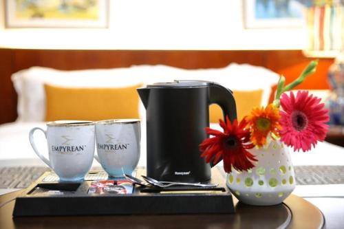 a coffee maker and two glasses on a table at Empyrean Dhaka City Centre in Dhaka