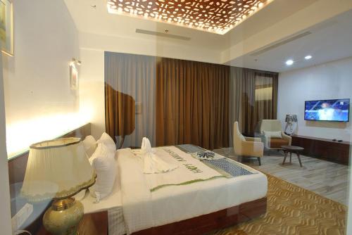 a hotel room with a bed and a living room at Empyrean Dhaka City Centre in Dhaka