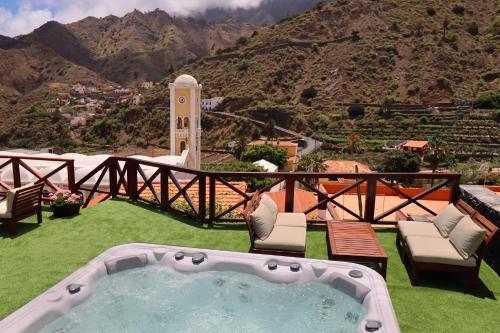a hot tub on a lawn with a view of a mountain at Hotel Escuela Rural Casa Los Herrera in Hermigua
