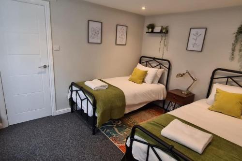 ein Schlafzimmer mit 2 Betten und einer Lampe an der Wand in der Unterkunft Morris Lodge, Southampton - 1 bedroom, Free WIFI & Parking in Southampton