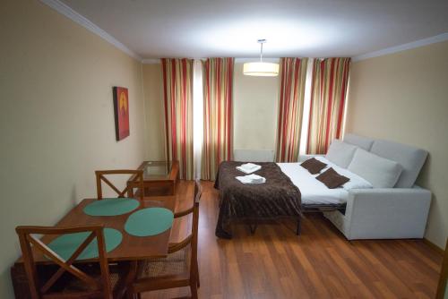 a room with a bed and a table and a couch at Cabalo Furado Tui in Tui