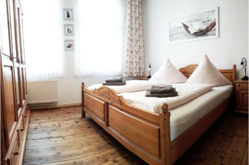 ein Schlafzimmer mit einem großen Holzbett mit weißer Bettwäsche in der Unterkunft Haus-Wolter in Goslar