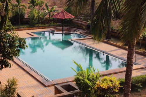 una vista aérea de una piscina con palmeras en Konkan Crown Resort & Club en Sawantwadi