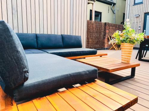 a blue couch and a coffee table on a deck at Bella's Place in Breda