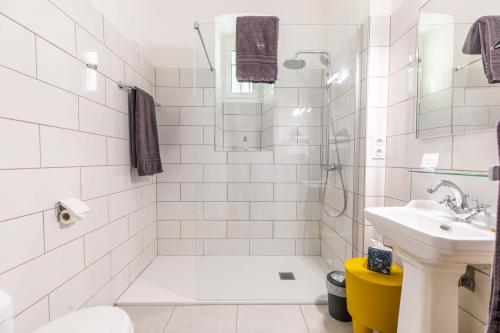 a white bathroom with a shower and a sink at Château de Charmeil- Vichy chambres d'hôtes in Charmeil