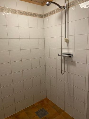uma casa de banho com um chuveiro com paredes em azulejos brancos em Lillfallet mysig fjällstuga med bästa läge på fjället em Sälen