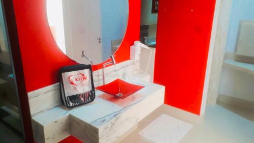 a bathroom with red walls and a red mirror at Motel Luxury in Votorantim