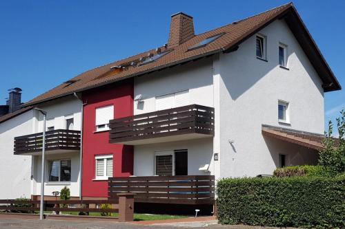 a white and red house with a brown roof at Ferienwohnung Familie Perl in Immenhausen