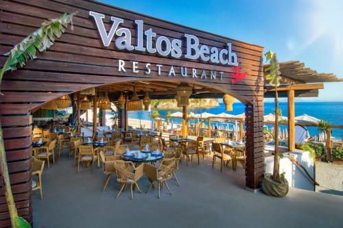 a restaurant on the beach with tables and chairs at Valtos Beach Hotel in Parga