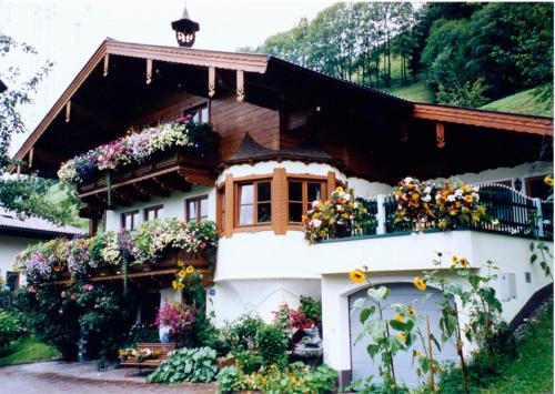 ein Haus mit Blumen auf der Seite in der Unterkunft Vorderkreuzsaalgut Rettenwender Gertraud in Wagrain