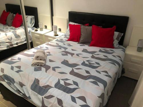 een slaapkamer met een groot bed met rode kussens bij Elche piso entero 3 dormitorios dobles in Elche