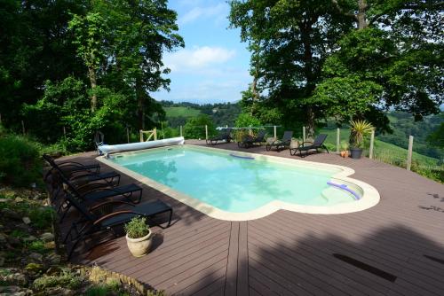 une piscine sur une terrasse en bois avec des chaises autour dans l'établissement Mountain retreat in the Pyrénées, glorious views, fire pit & pool - Sleeps 14, à Ossun-ez-Angles
