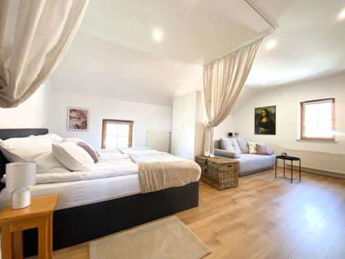 1 dormitorio con 1 cama grande y 1 sofá en Fado Apartments Gornja Radgona, en Gornja Radgona