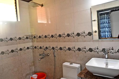 a bathroom with a sink and a toilet at Sirimane Homestay - Swimming Pool, Food, Near to Falls & Trek in Sakleshpur