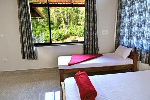 a room with two beds and a window at Sirimane Homestay - Swimming Pool, Food, Near to Falls & Trek in Sakleshpur