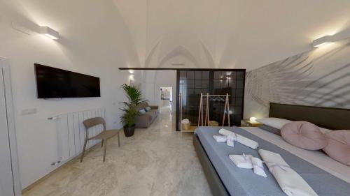 a bedroom with two beds and a tv on a wall at Zephir Apartments in Brindisi