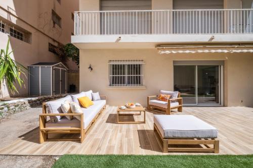 d'une terrasse avec un canapé, des chaises et une table. dans l'établissement SERRENDY  COUP DE COEUR !  3p avec jacuzzi à pieds de la Croisette !, à Cannes