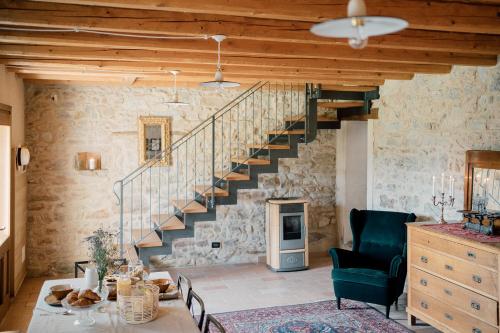 a living room with a staircase in a stone wall at Agriturismo Il Conte Vassallo in Miane