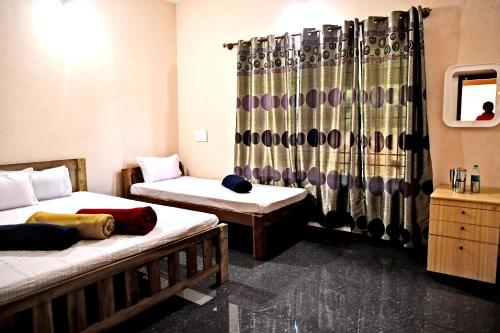 a room with two beds and a shower curtain at Sirimane Homestay - Swimming Pool, Food, Near to Falls & Trek in Sakleshpur