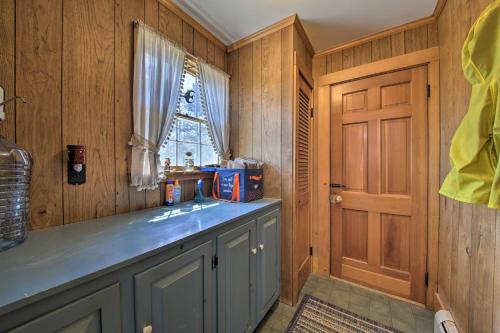 a kitchen with wood paneling and a sink and a window at Cozy Colonial Home with Bay Access and Water View in Bucksport