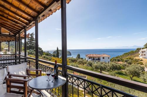 a balcony with a table and two glasses of wine at Irida Apartments in Stafylos