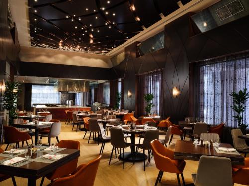 a restaurant with tables and chairs and a bar at Hyatt Centric Wall Street New York in New York