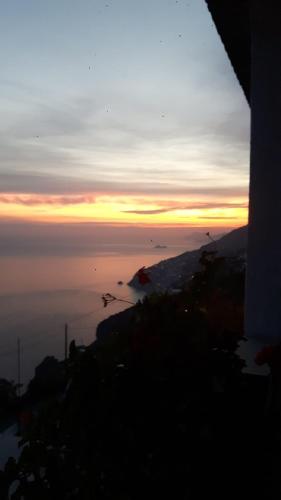a view of the ocean with the sun setting in the background at Casa Barbara in Amalfi