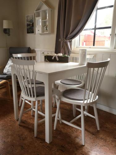 a white dining room table and chairs with a window at Dalastugan in Mora