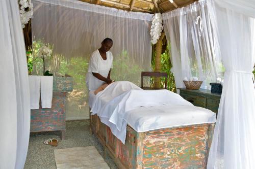 a woman standing next to a bed in a room at Casa Grande Hotel Restaurant in Las Terrenas