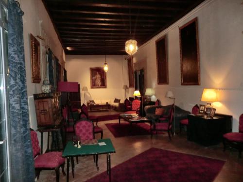 a living room with red chairs and a couch at Palacio de la Rambla in Úbeda