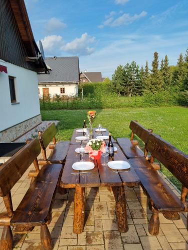 a wooden table with plates on it on a patio at Villa Harta in Vrchlabí