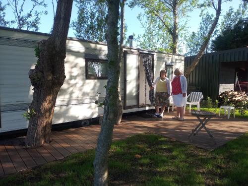 two women standing outside of a tiny house at De Boerenskuur..chalet.. in Assendelft