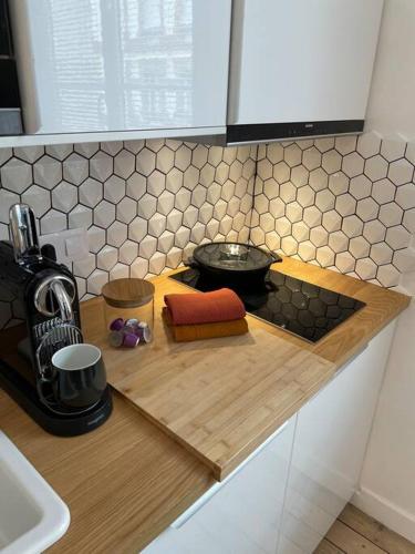 - une cuisine avec un comptoir et une cafetière dans l'établissement La Nacre - Logement de charme - Cabourg, à Cabourg