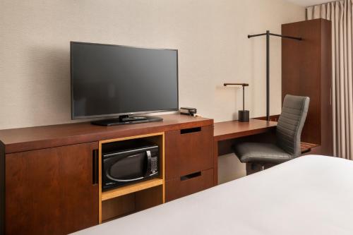 a room with a tv and a desk with a chair at Comfort Inn West in Ottawa