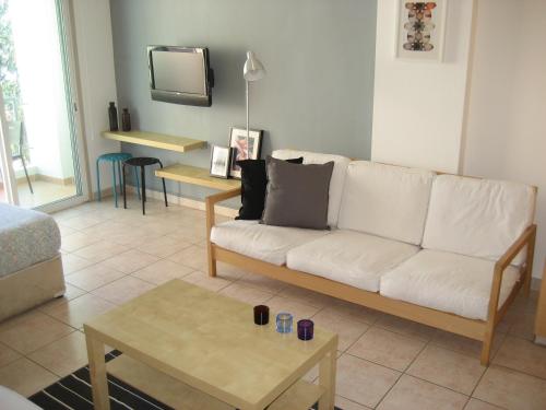 a living room with a white couch and a table at Lykavitos Apartments in Nicosia