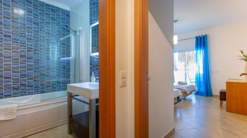 a bathroom with a sink and a tub and a window at Quinta da Arbrotea in Lagos